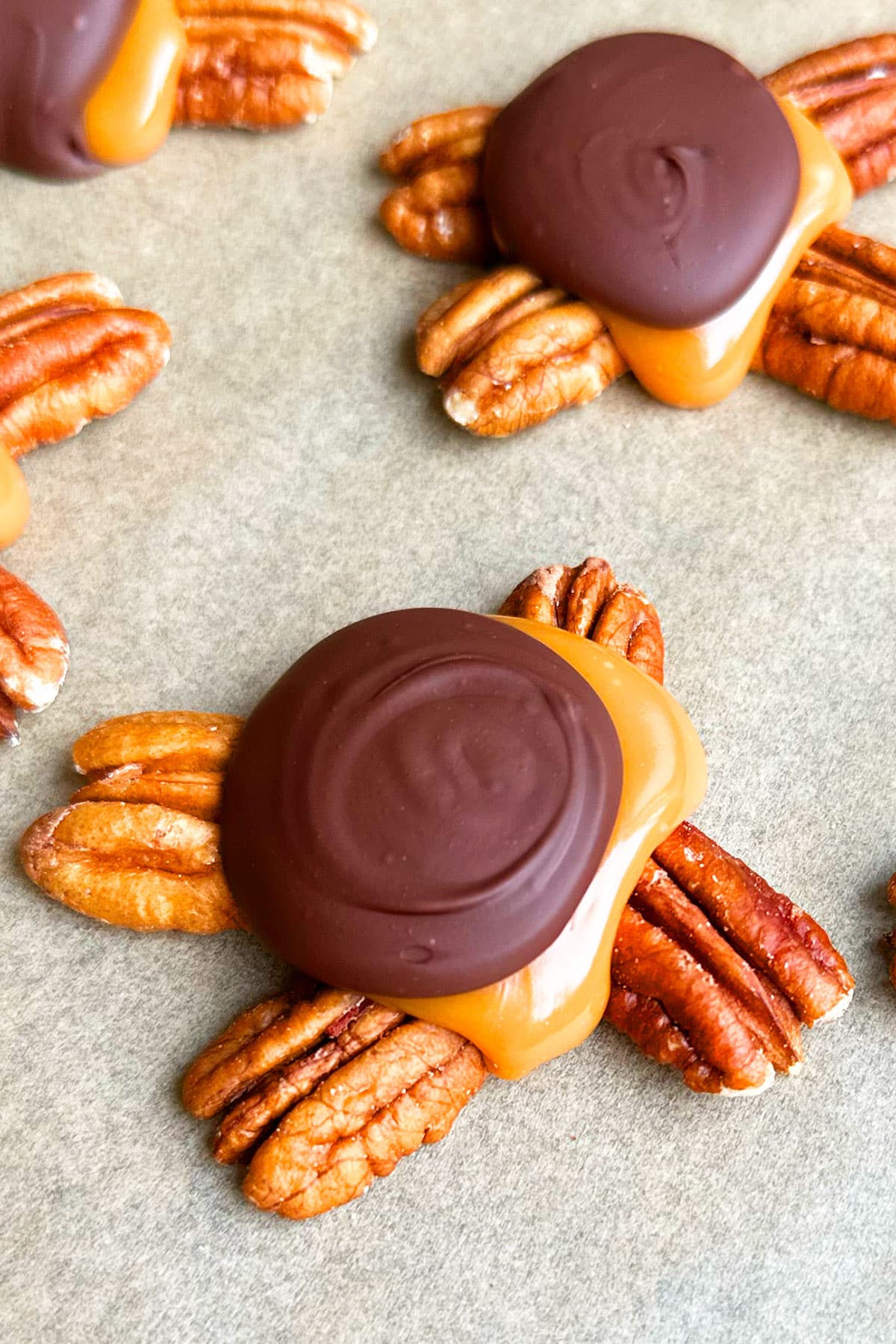 Closeup Shot of Chocolate Caramel Pecan Cluster on Brown Wax Paper. 