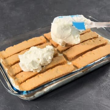 Second layer of chai soaked cake rusks and mascarpone filling being arranged. 