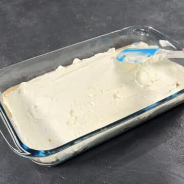 Mascarpone filling being spread out evenly with a rubber spatula. 