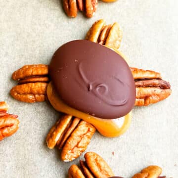Easy Homemade Chocolate Turtles With Caramel and Pecans on Brown Wax Paper- Closeup Shot.