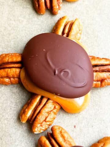 Easy Homemade Chocolate Turtles With Caramel and Pecans on Brown Wax Paper- Closeup Shot.