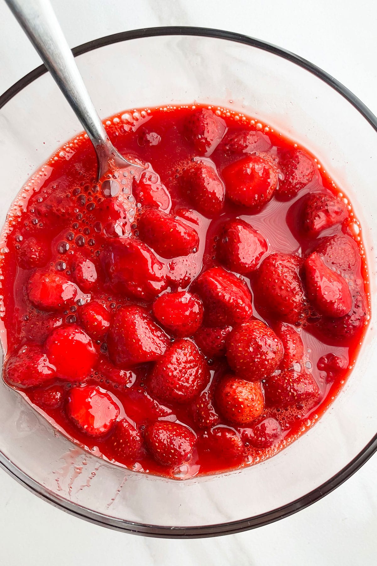 Easy Homemade Macerated Strawberries in Glass Bowl With Stainless Steel Spoon. 