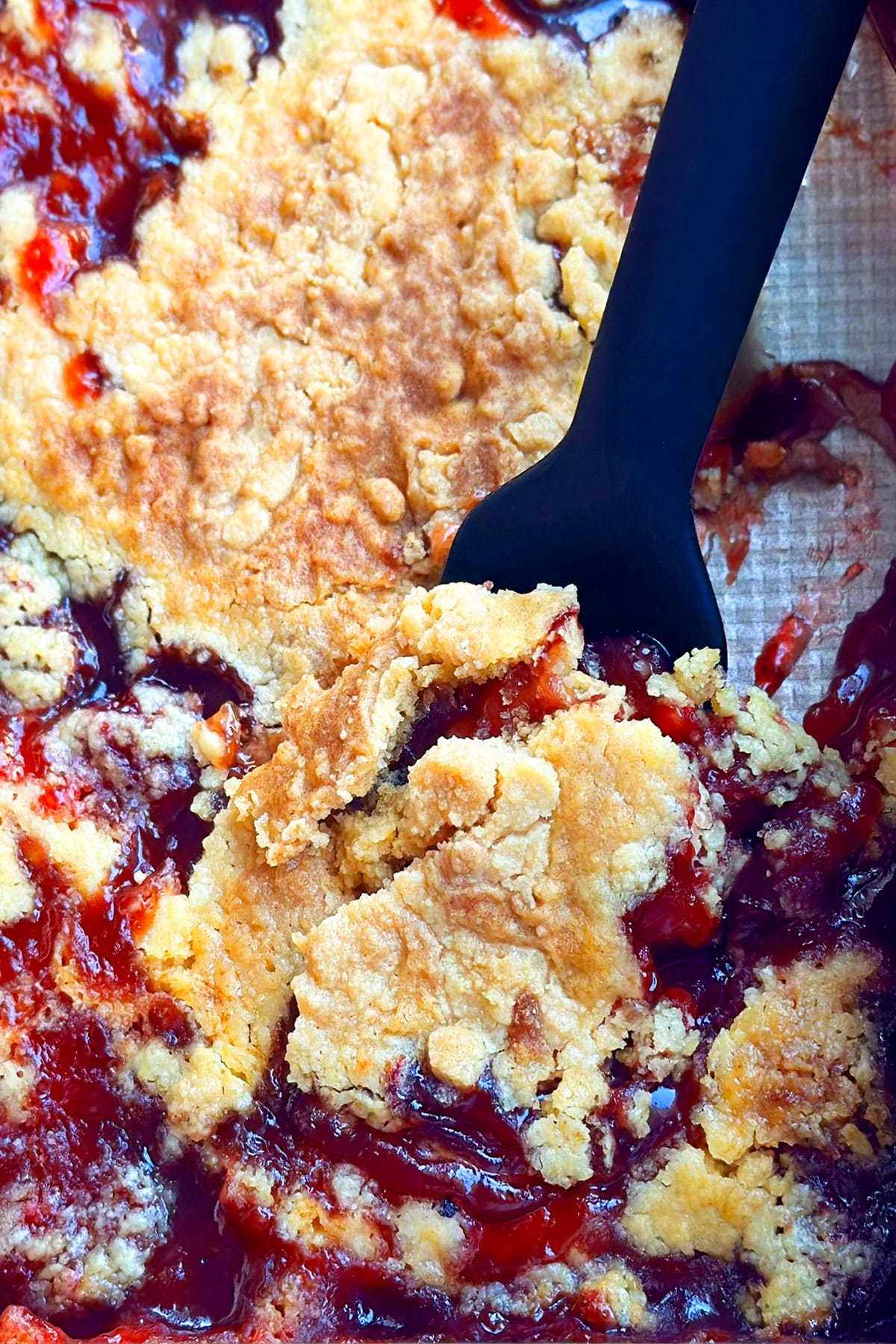 Closeup shot of spoonful of strawberry cobbler cake. 