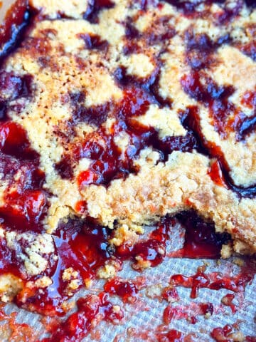 Partially eaten easy strawberry dump cake with cake mix in a rectangle stainless steel pan.