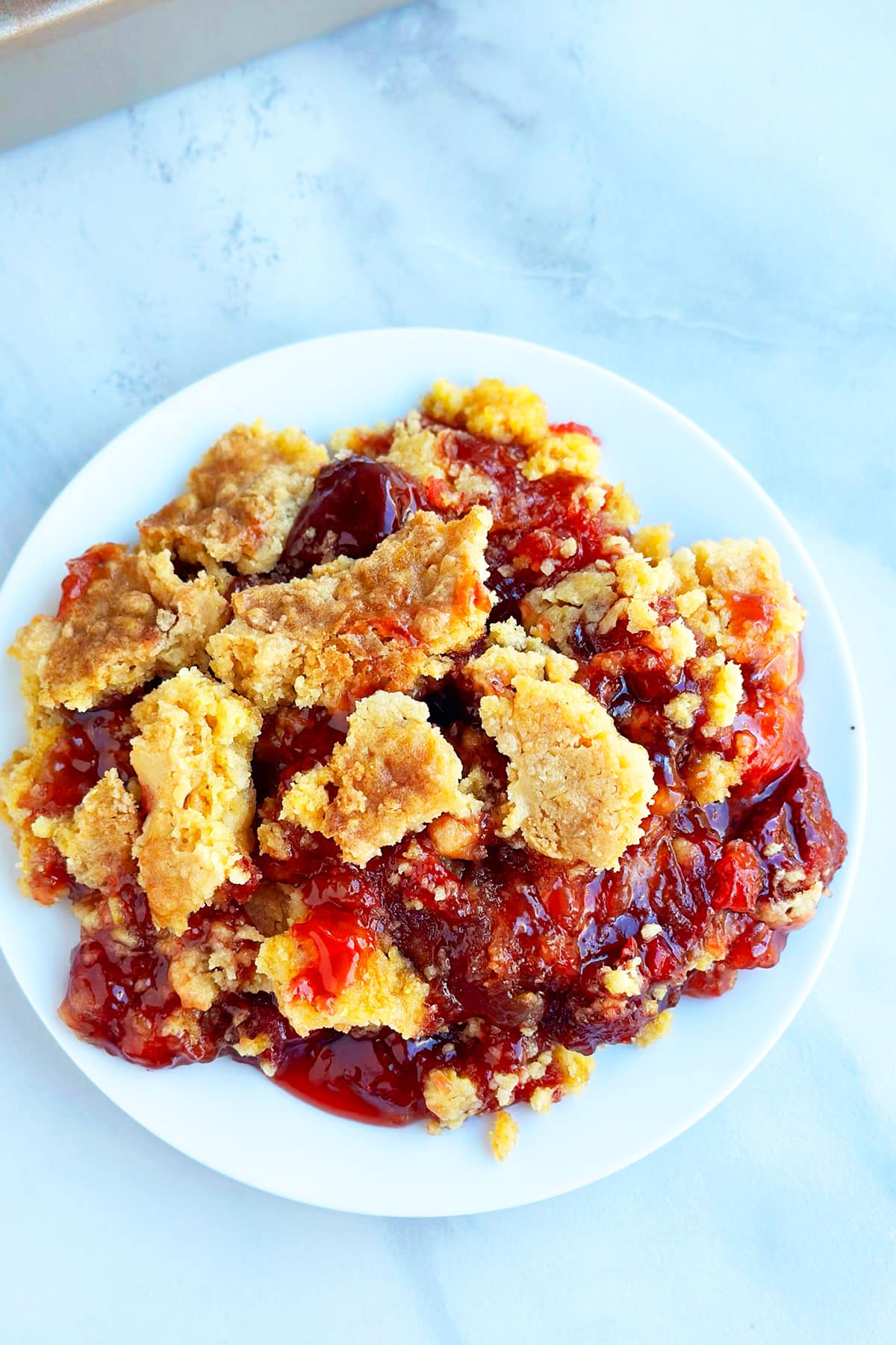 Strawberry crumble cake in white dish- Overhead shot. 