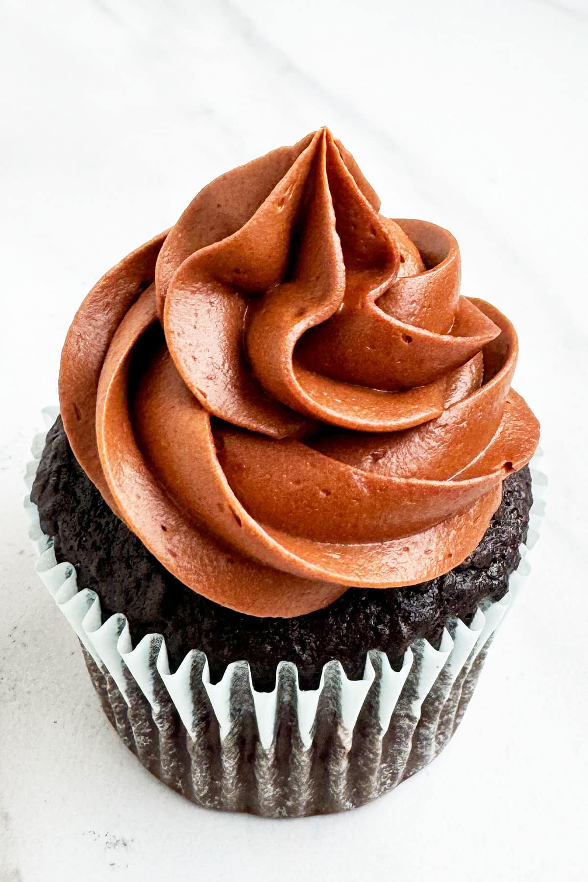 Swirl of Easy Mocha Buttercream Frosting With Espresso Coffee on Chocolate Cupcake With White Background.