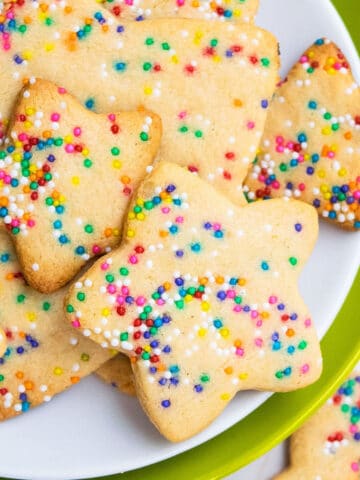 Easy Star Shaped Cut Out Funfetti Cookies With Rainbow Sprinkles on White and Green Dish.