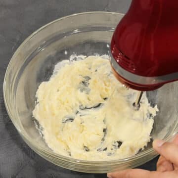 Butter being creamed in glass bowl.