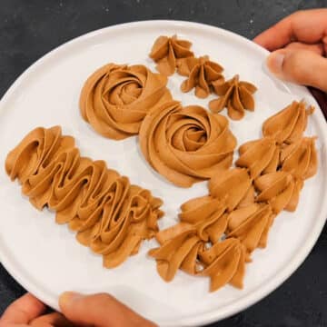 Piped icing designs on white dish.