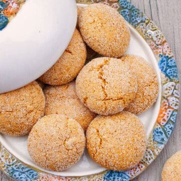 Best Easy Ginger Molasses Cookies in White Dish With Colorful Rim on Rustic Gray Background.