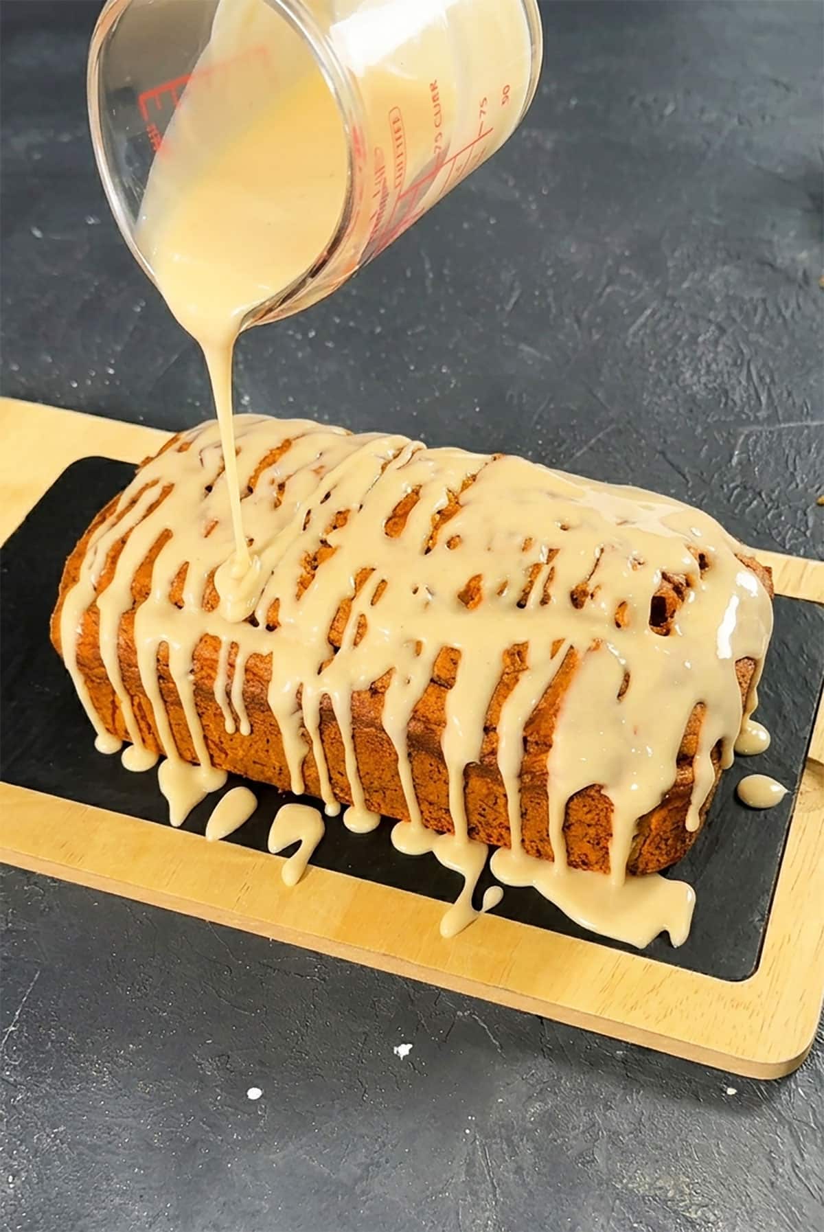 Maple Drizzle Icing Being Poured on Top of a Loaf Cake. 