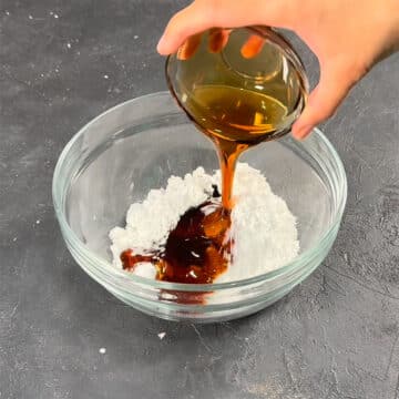 Maple syrup and powdered sugar in glass bowl. 