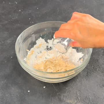 Water being added to other ingredients in bowl. 