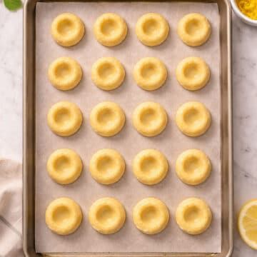 Empty thumbprints on lined baking tray. 